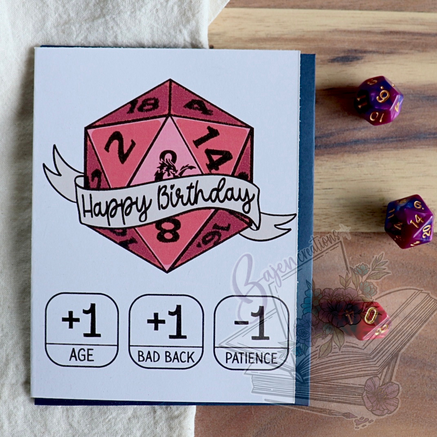 Birthday card with a red die design and dice on a wooden surface