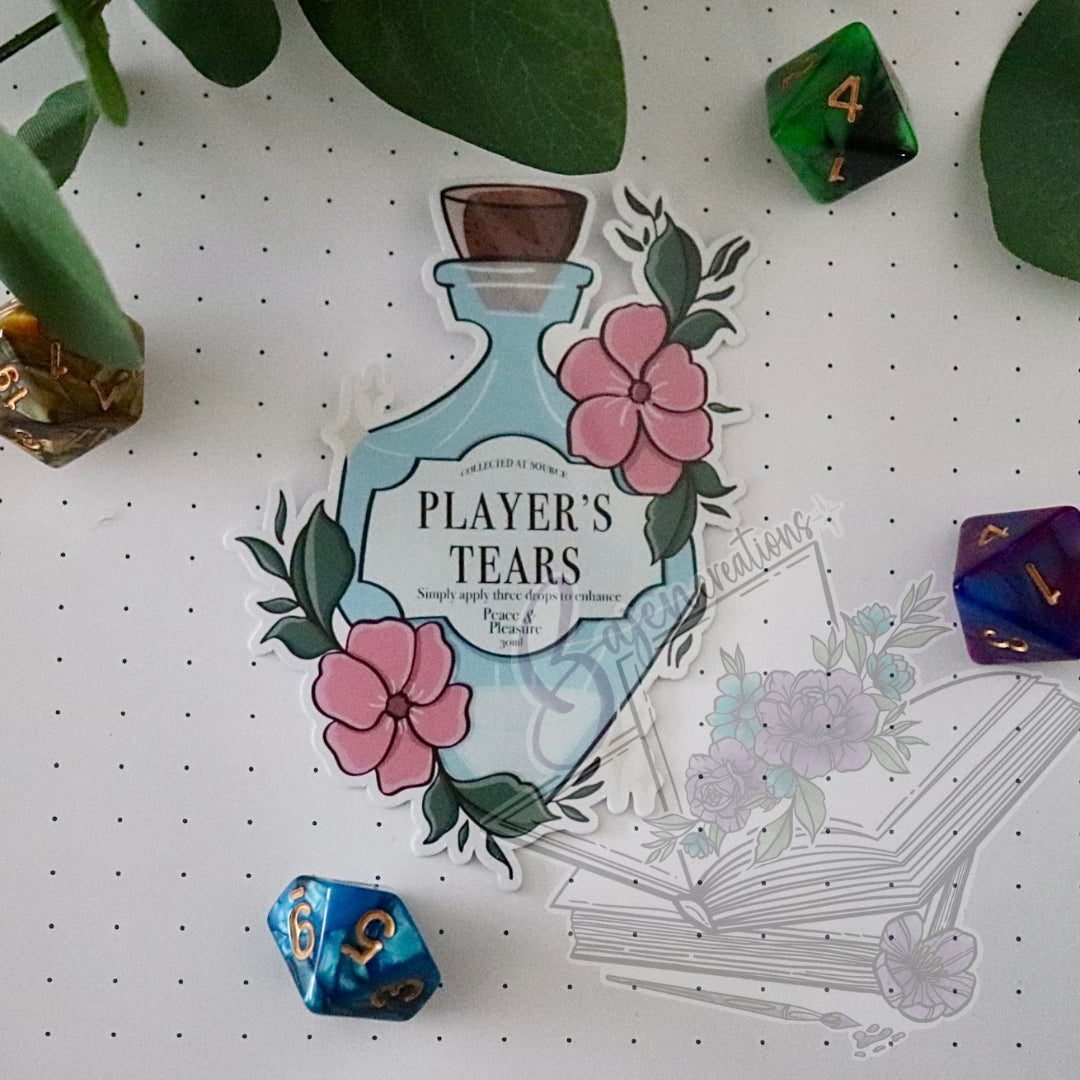 Sticker of a potion bottle labeled 'Player's Tears' on a white surface with dice and plants.