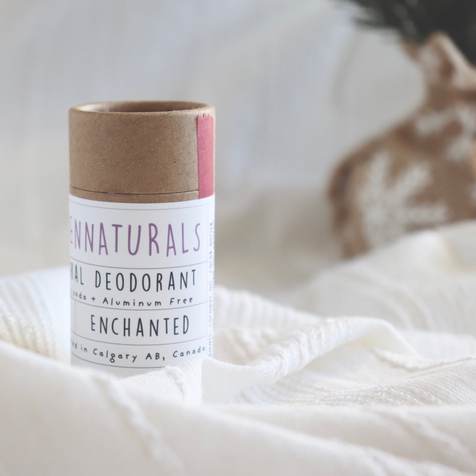 A brown craft tube of deodorant with a white and pink label